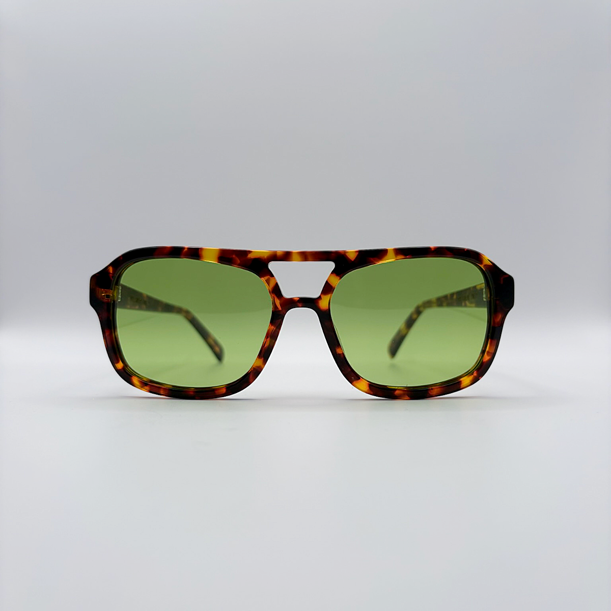 Close-up of vintage-inspired frame crafted from premium brown tortoiseshell acetate and yellow green tinted lensesfrom independent rock ’n’ roll–inspired eyewear brand Dirty Rocker. David Bowie inspired sunglasses.