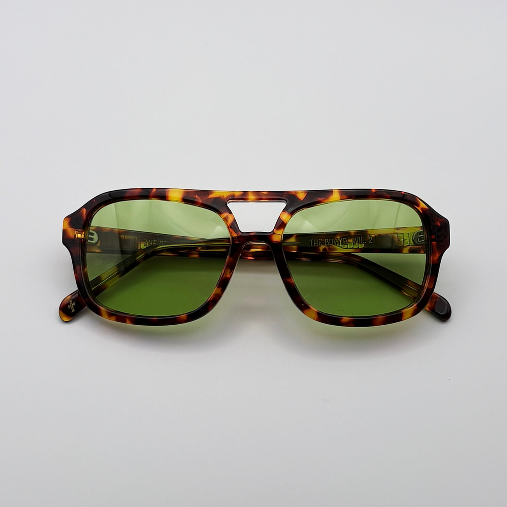 Close-up of vintage-inspired frame crafted from premium brown tortoiseshell acetate and yellow green tinted lensesfrom independent rock ’n’ roll–inspired eyewear brand Dirty Rocker. David Bowie inspired sunglasses.