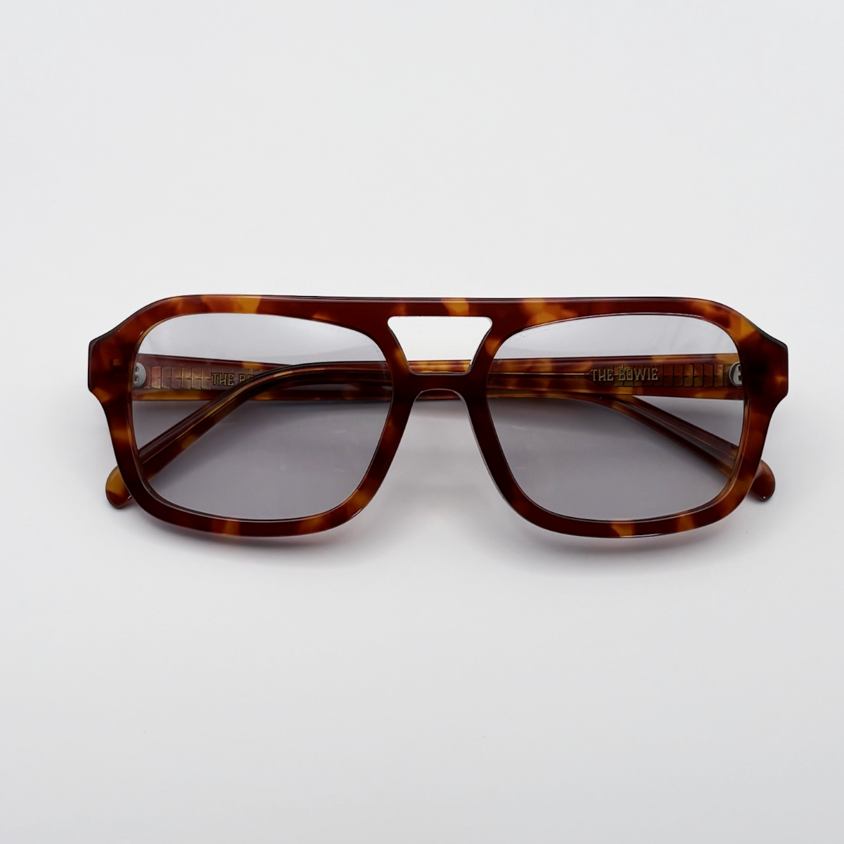 Close-up of vintage-inspired frame crafted from premium brown tortoiseshell acetate and grey-tinted lensesfrom independent rock ’n’ roll–inspired eyewear brand Dirty Rocker. David Bowie inspired sunglasses.