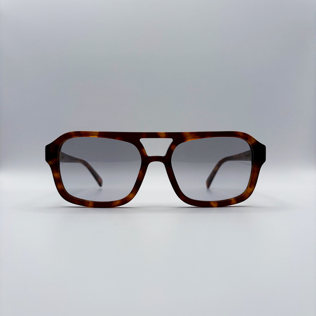 Close-up of vintage-inspired frame crafted from premium brown tortoiseshell acetate and grey-tinted lensesfrom independent rock ’n’ roll–inspired eyewear brand Dirty Rocker. David Bowie inspired sunglasses.