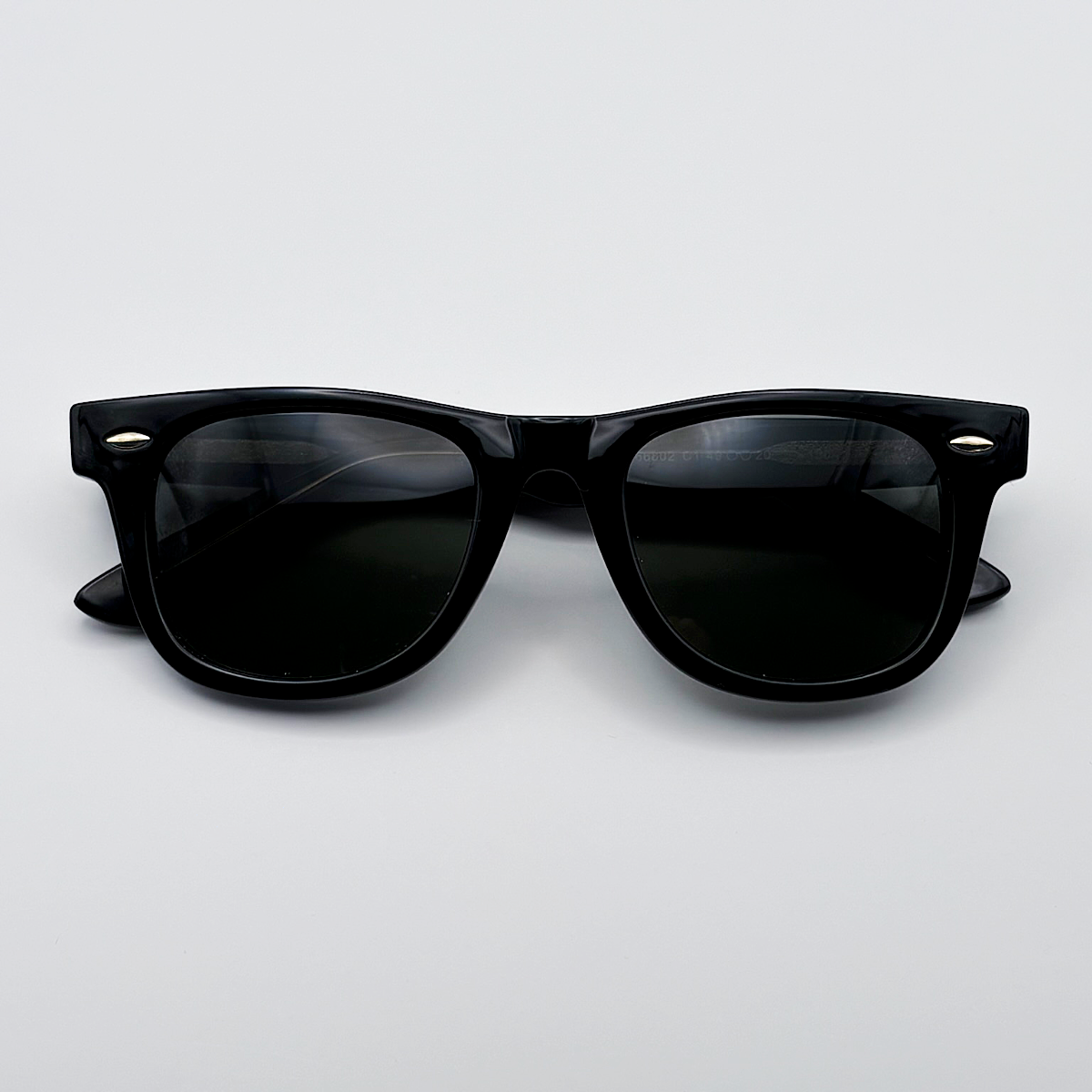 Close-up of vintage-inspired solid black Wayfarer frame with a high-gloss finish and black polarised lenses unisex vintage inspired tinted sunglasses from independent rock ’n’ roll–inspired eyewear brand Dirty Rocker 