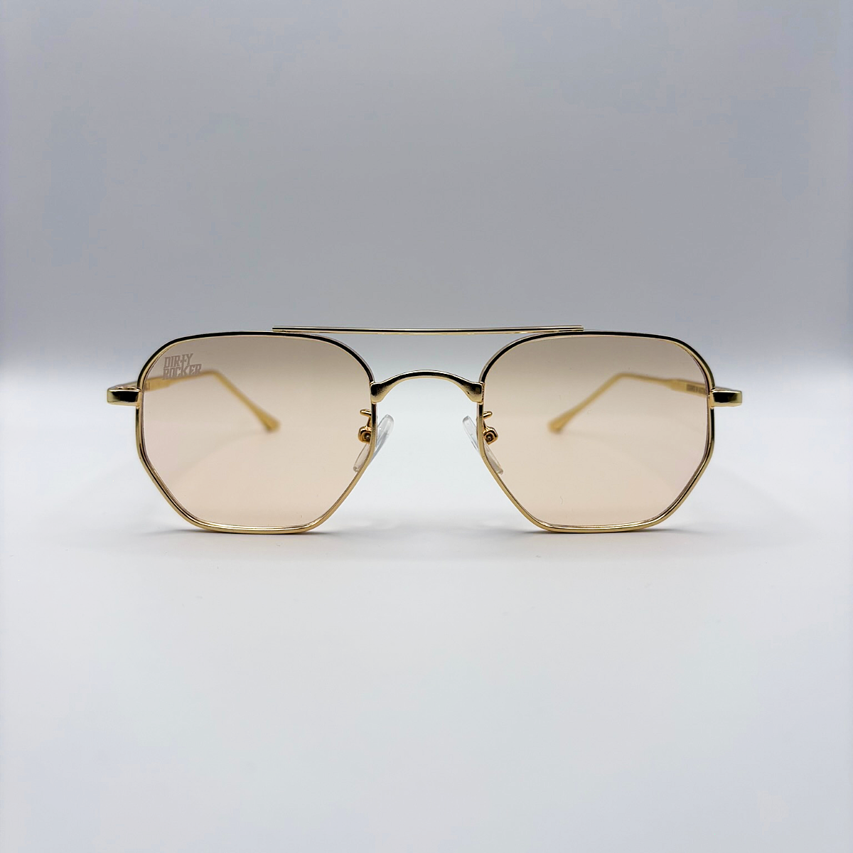 Gold-framed sunglasses with a light brown lens on a light gray background